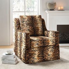 a tiger print chair sitting in front of a fire place with books on the floor