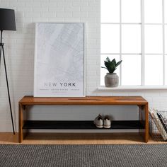 a wooden bench sitting in front of a window next to a lamp and potted plant