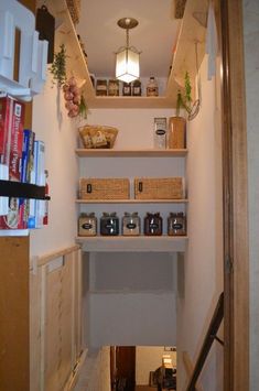 a narrow hallway with shelves and baskets on the wall