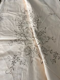 two white bedspreads with black flowers on them