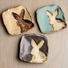 three small ceramic dishes with rabbits on them