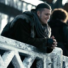 a man in winter clothes sitting on a bench