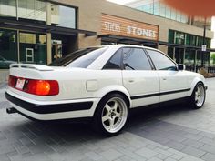 a white car parked in front of a store