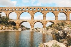 an old stone bridge over a body of water with arches on it's sides