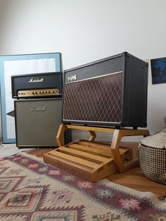 two amps sitting on top of a wooden stand