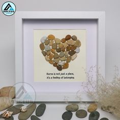 a heart made out of rocks with the words home is not just a place, it's a feeling of belonging