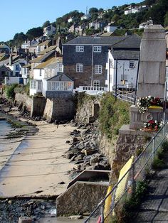 the beach is lined with houses and buildings along it's shore line, as seen from across the water