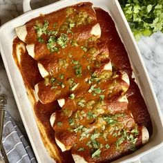 a casserole dish with meat and vegetables in it on a marble counter top