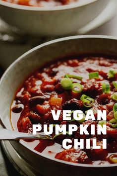 a bowl of vegan pumpkin chili with a spoon in it and the words, vegan pumpkin chili