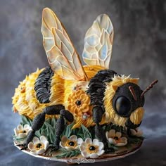 a cake made to look like a bee with flowers on it's back legs