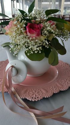 a white tea pot with pink roses and baby's breath