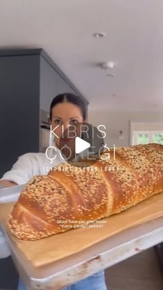 a woman holding a large loaf of bread