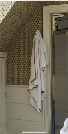 a white towel hanging on the side of a door