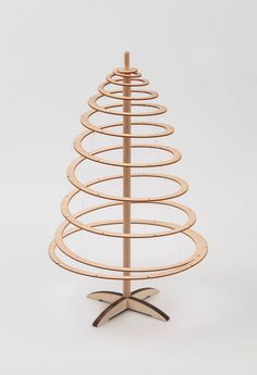 a small wooden christmas tree with spirals on the top and base, standing in front of a white background