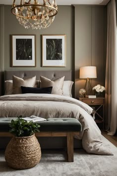 a bedroom with a large bed and two pictures on the wall above it, along with a footstool