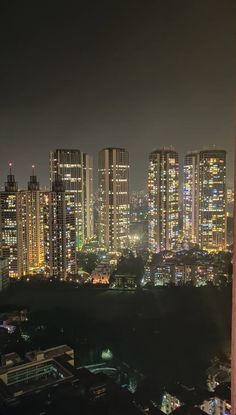 the city is lit up at night and it looks like there are buildings in the distance