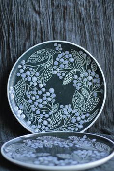 two plates sitting next to each other on top of a black cloth covered tablecloth