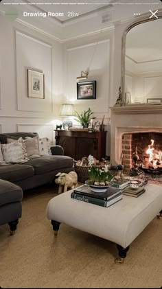 a living room filled with furniture and a fire place under a mirror on the wall