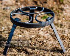 a metal object sitting on top of a field covered in dirt and grass with one leg sticking out