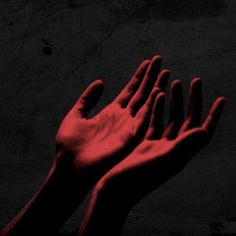 two hands reaching up into the air with red light coming from their fingertipss on a black background