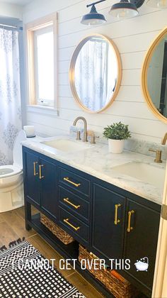 a bathroom with two round mirrors above the sink and a rug on the floor next to it