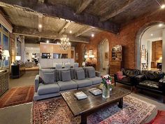 a living room with couches, tables and rugs on the floor in front of an arched doorway