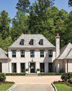 a large white brick house surrounded by trees