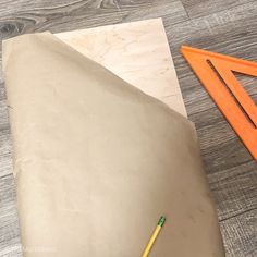 a piece of paper with a pencil next to it on top of a wooden table