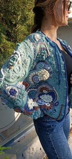 a woman is standing outside wearing a crocheted jacket