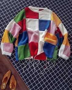 a colorful sweater and pair of sandals on a table