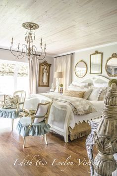 a bedroom with a bed, chandelier and two chairs