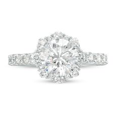 a diamond engagement ring with an oval center surrounded by round brilliant cut diamonds and pave set shoulders