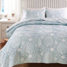 a bed with blue and white bedspread in a bedroom