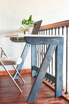 a wooden table sitting on top of a hard wood floor next to a white chair