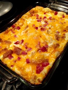 a casserole dish sitting on top of an oven with cheese and bacon in it