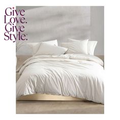 a bed with white sheets and pillows in front of a sign that says give love give style