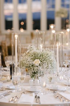 the table is set with white flowers and candles