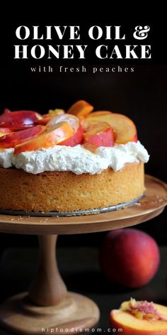 a cake with fresh peaches on top and the words olive oil & honey cake above it