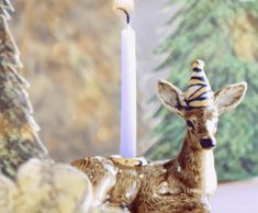 a deer figurine sitting next to a lit candle