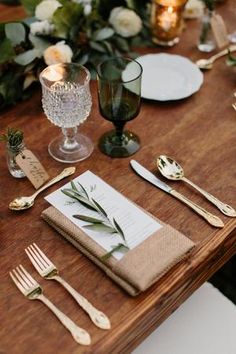 the table is set with silverware, napkins and place settings for an elegant dinner