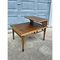 a small wooden table sitting in front of a garage door