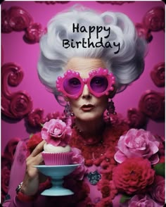 a woman in pink glasses holding a cupcake with the words happy birthday written on it