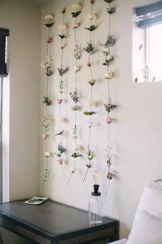 a wall hanging with flowers on it next to a table