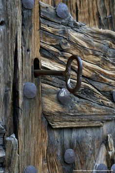 an old wooden door with metal rings on it