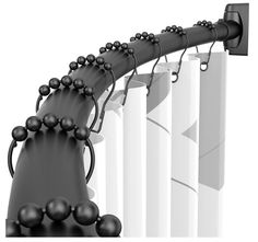 a black and white photo of a curtain with balls hanging from it's side