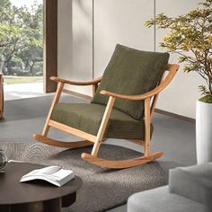 a rocking chair in a living room next to a table with a book on it