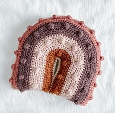 a crocheted pot holder with a hole in the middle on a white surface