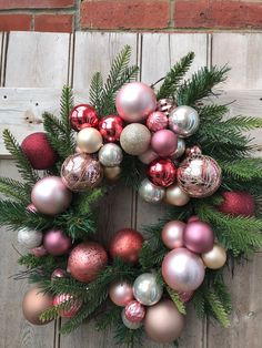 a wreath with christmas ornaments hanging from it