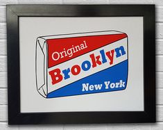 an original brooklyn new york sign hangs on a white brick wall in front of a black frame