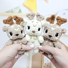 three small stuffed animals held in their hands